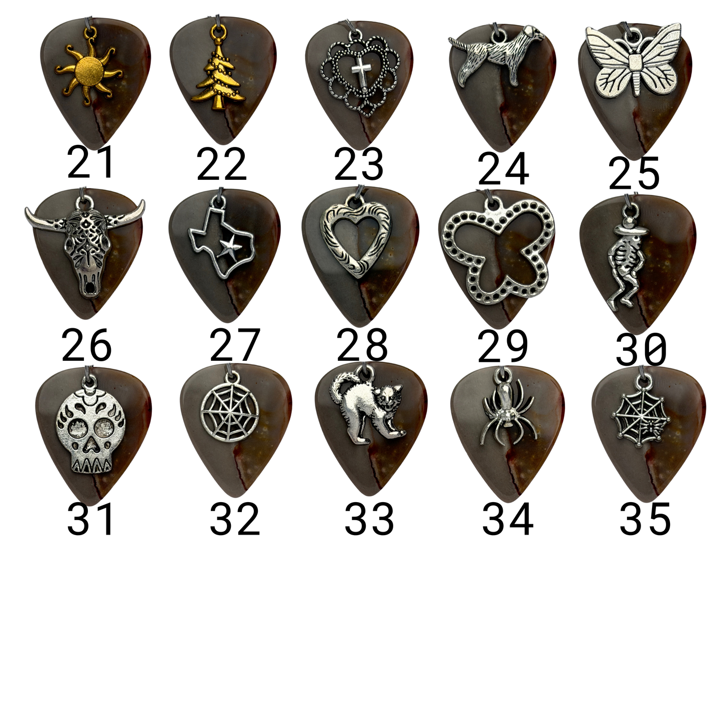 Array of charms exampled on guitar pick 
Charm 21 : Gold sun
Charm 22: Gold Christmas tree
Charm 23:  Heart and cross
Charm 24: standing dog charm
Charm 25: large butterfly
Charm 26: longhorn
Charm 27: Texas
Charm 28: Heart
Charm 29: XL Butterfly
Charm 30: skeleton with hat
Charm 31:  Skull
Charm 32: Round Spiderweb
Charm 33: Scaredy Cat
Charm 34: Spider
Charm 35: Spiderweb