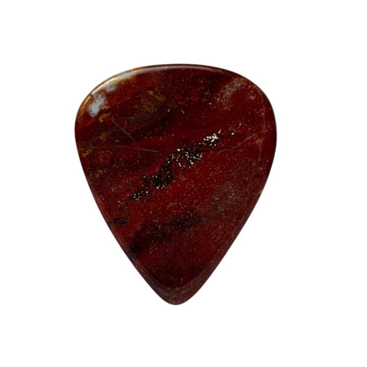 handmade standard stone guitar pick made of polished red jasper stone with natural dark veining and metallic gold flecks, shown on a solid white background.