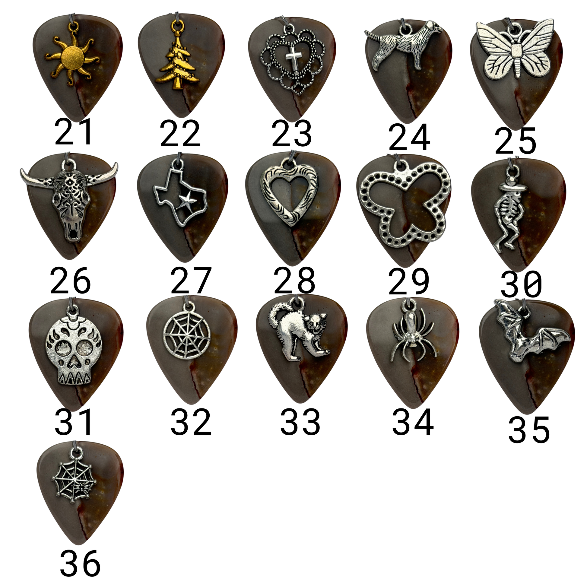 Array of charms exampled on guitar pick 
Charm 21 : Gold sun
Charm 22: Gold Christmas tree
Charm 23:  Heart and cross
Charm 24: standing dog charm
Charm 25: large butterfly
Charm 26: longhorn
Charm 27: Texas
Charm 28: Heart
Charm 29: XL Butterfly
Charm 30: skeleton with hat
Charm 31:  Skull
Charm 32: Round Spiderweb
Charm 33: Scaredy Cat
Charm 34: Spider
Charm 35: Bat 
Charm 36: Spiderweb